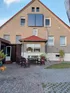 Außenansicht des großzügigen Mehrgenerationenanwesens in Fredersdorf mit gepflegtem Garten und Einfahrt.